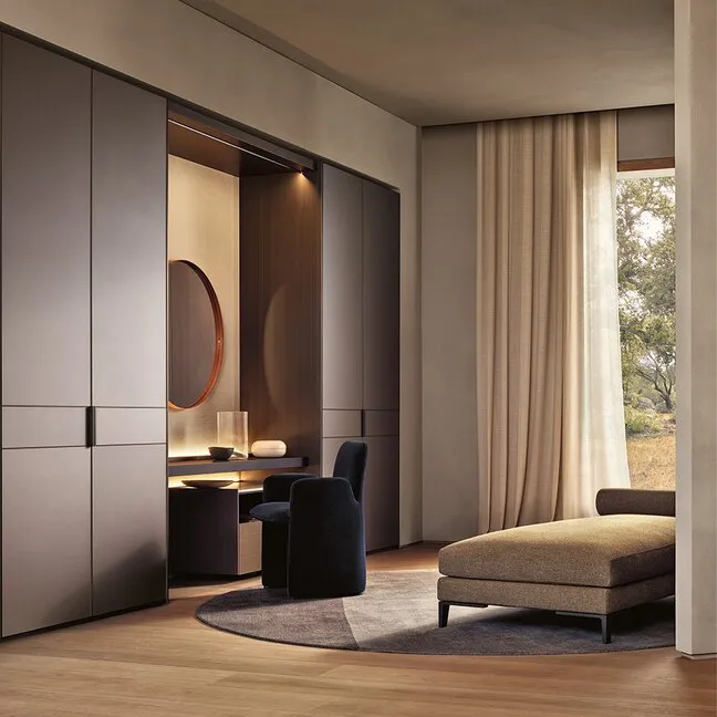 Luxury built-in wardrobe with integrated vanity desk and minimalist cabinetry by Ajwaad Palace, premium dressing room furniture in Muscat, Oman.
