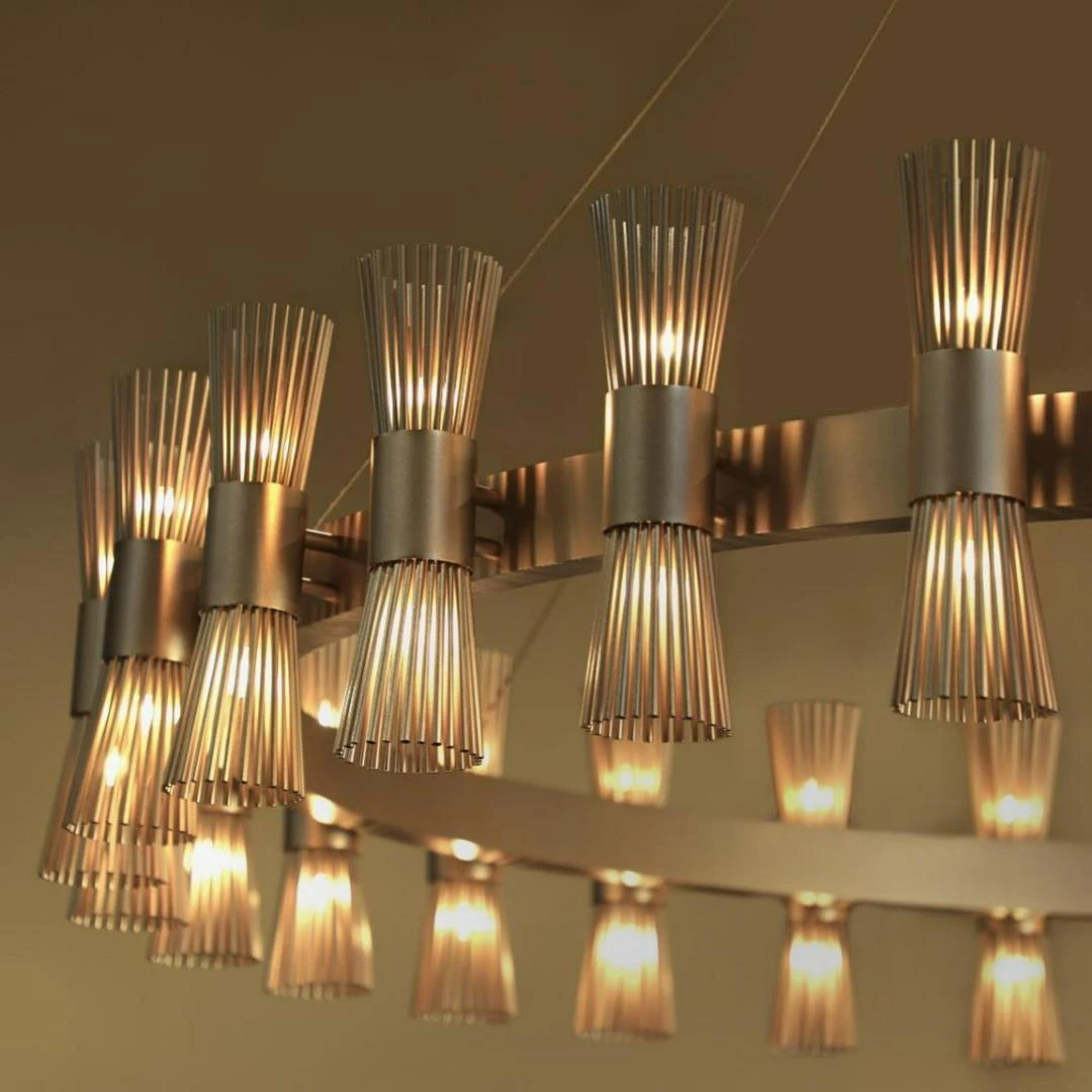 Modern designer brass chandelier with unique vertical light elements by Castro Lighting at Ajwaad Palace showroom, Muscat, Oman.
